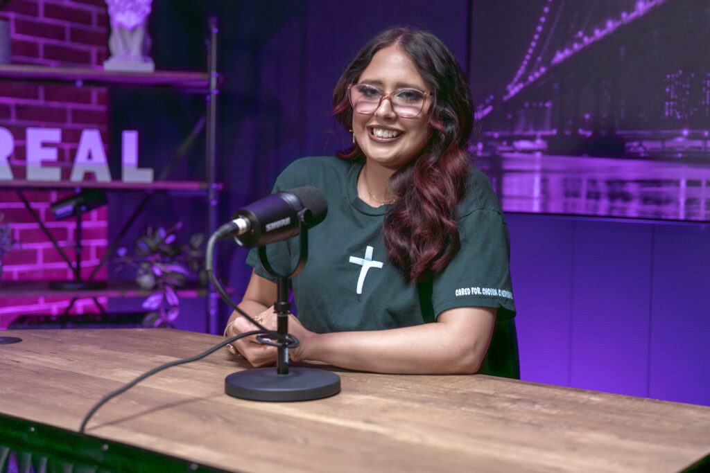 Podcast host Savanna setting at her podcast desk with her microphone